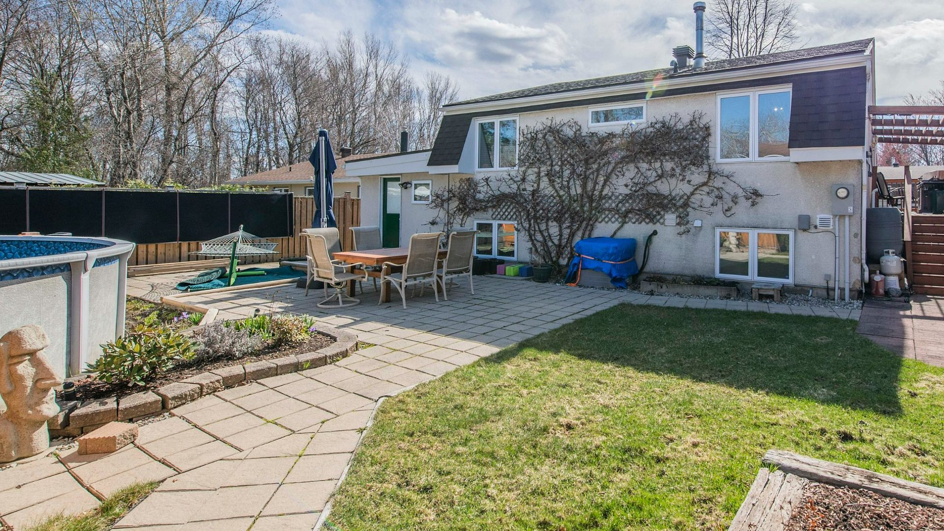 The yard before: above-ground pool, old pavers, bare vines on the wall