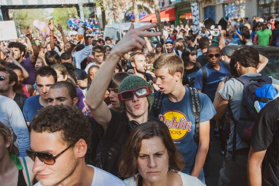 Closer in the crowd, a hand thrown up